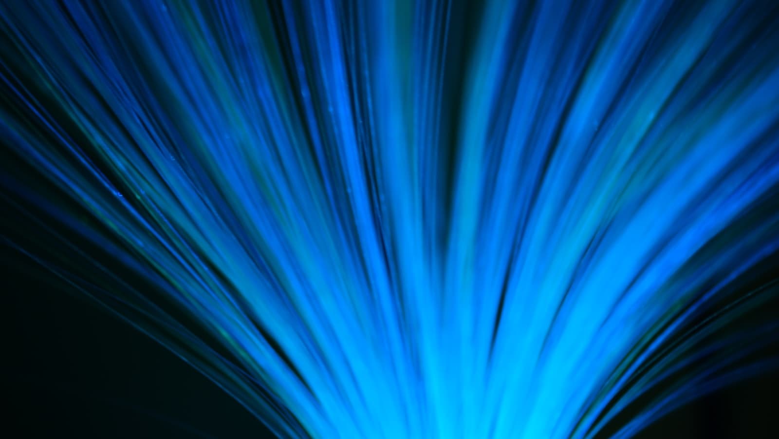 Blue fiber optic cables radiating outward against a dark background.