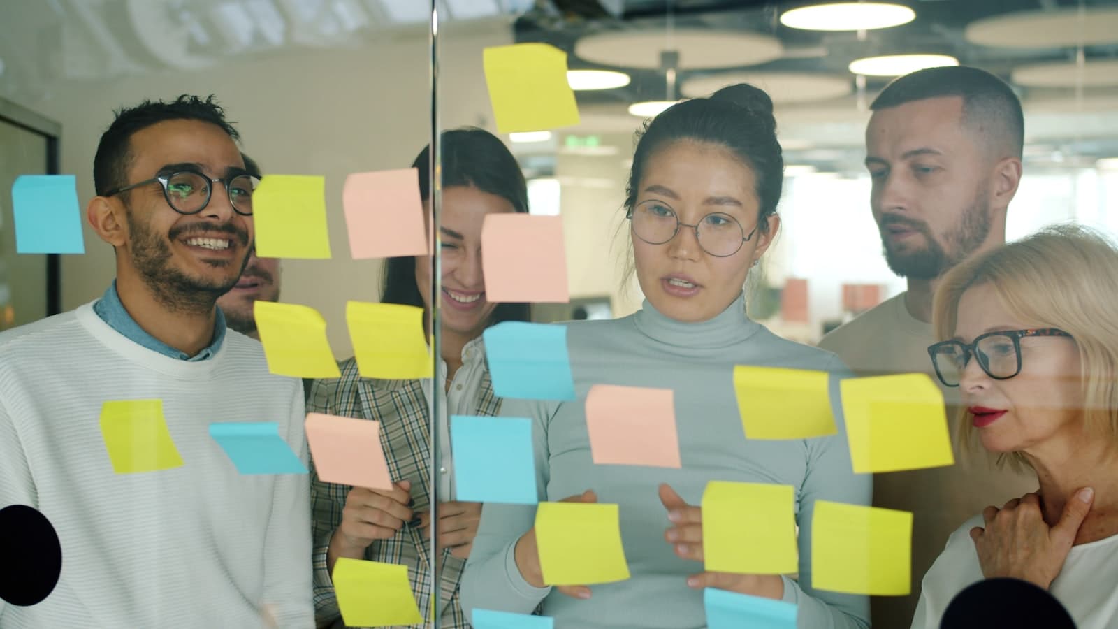 Team planning a product roadmap on a whiteboard with sticky notes.